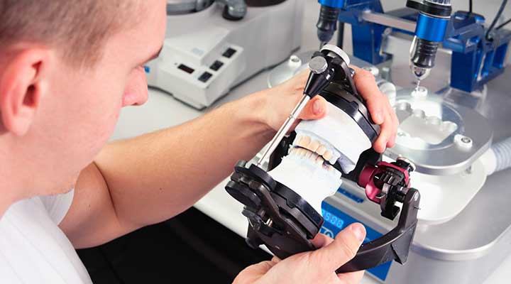 Man using computer aided design (CAD) to manufacture a ceramic crown