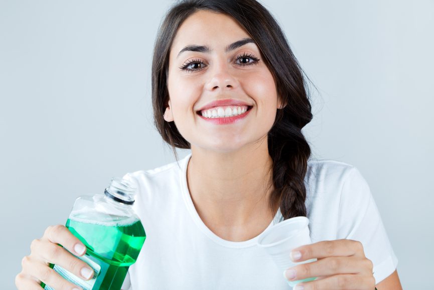 Portrait of girl using mouthwash