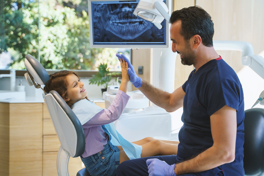 Dentist talking to child in the dental office.