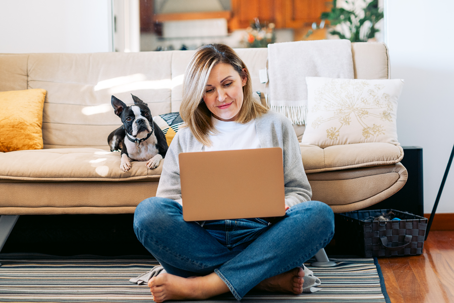 Girl checking here dental benefits online with her dog by her side.